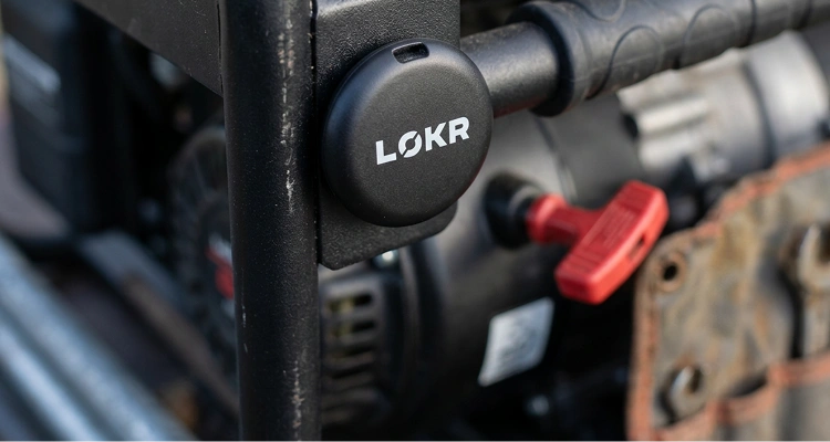 LOKR tracking tag is mounted onto a black metal frame of a generator or piece of machinery.